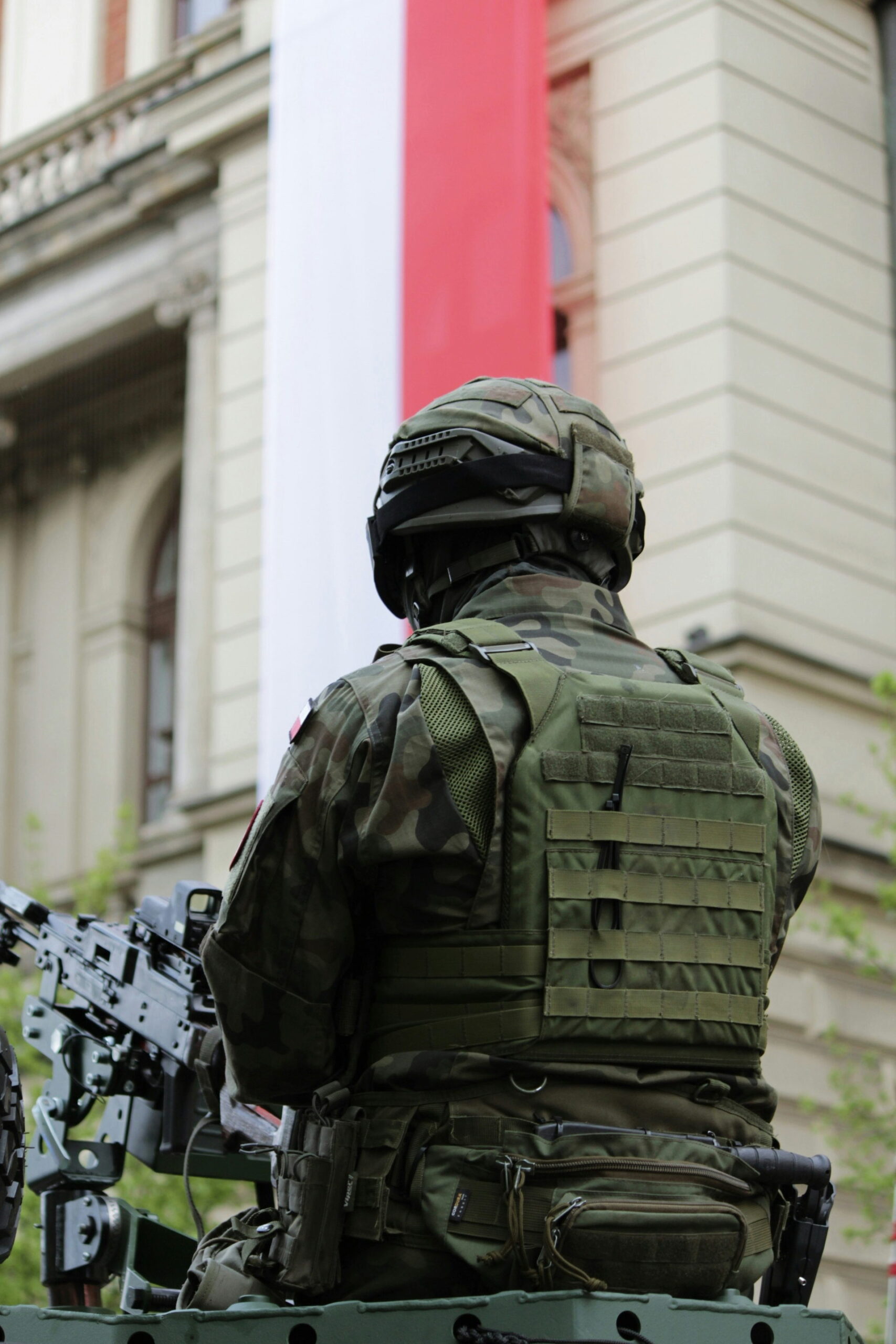 Żołnierz na tle biało-czerwonej flagi